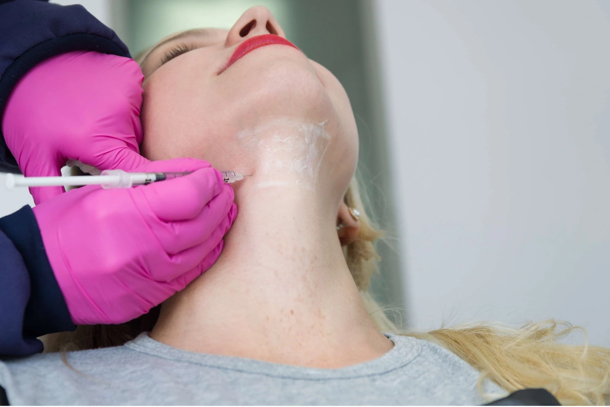 Woman receiving Kybella injection under the chin for double chin reduction